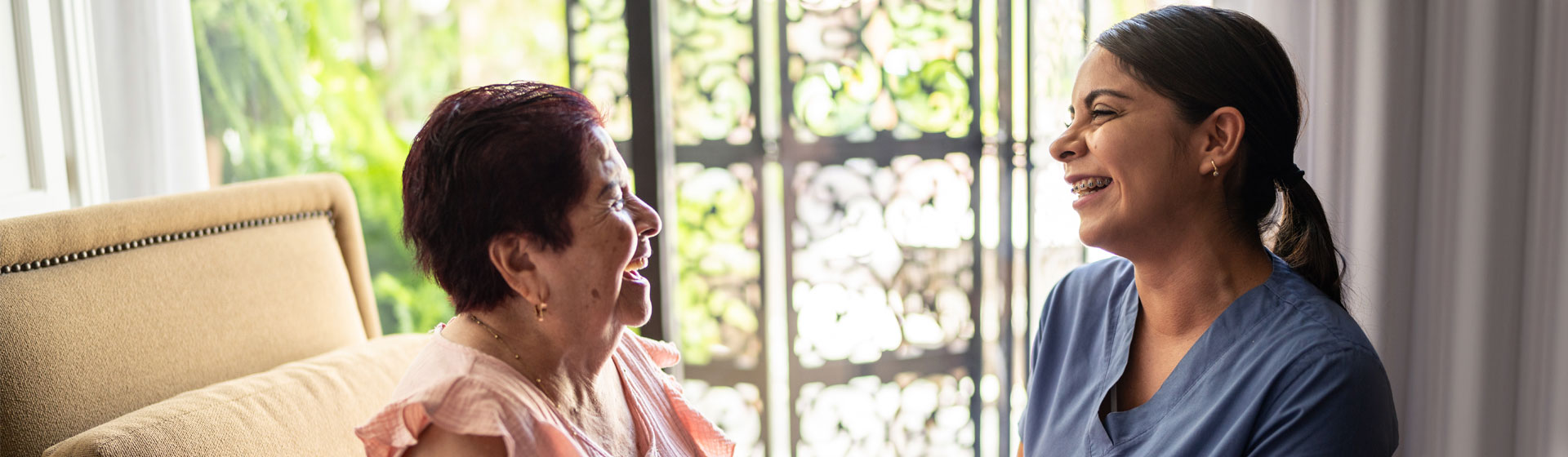Elderly woman smiling at health care worker