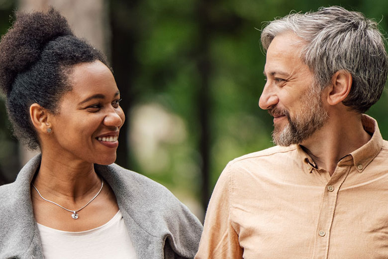 Woman and man smiling at each other outside